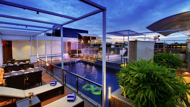 A rooftop pool area with lounge seating and a bar. - Lavender Premier (Bengaluru)