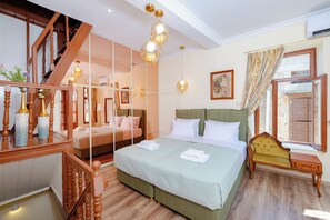 Um quarto com uma cama grande, um banco de madeira, uma escada e um espelho.