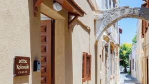 Una estrecha calle adoquinada con edificios a ambos lados, un cartel que dice 