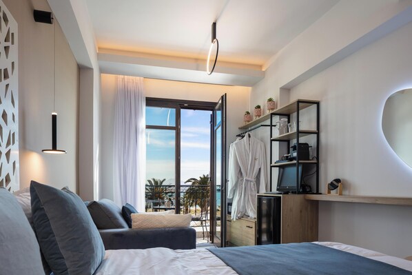 Une chambre d’hôtel moderne équipée d’un lit, d’un bureau, d’une chaise, d’une armoire et offrant une vue sur l’extérieur.