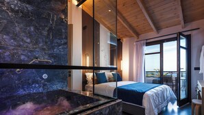A modern bedroom with a large bed, a glass shower enclosure, and a balcony with a view.