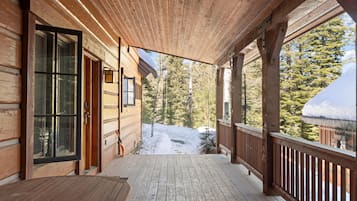 A wooden cabin with a covered porch, a door, and a window.