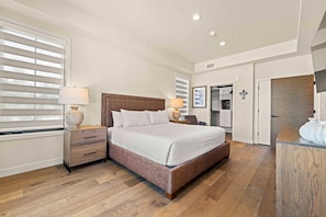 A bedroom with a bed, bedside tables, a wardrobe, and a bathroom visible through an open door. - Alpine Glow Retreat | Exclusive Tamarack Perks (Tamarack)