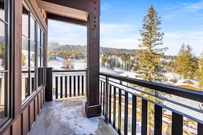 A balcony with a view of a snowy landscape and a forest. - Alpine Glow Retreat | Exclusive Tamarack Perks (Tamarack)