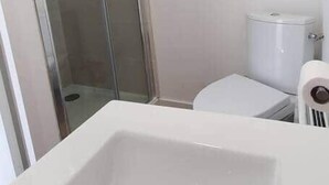 A modern bathroom with a glass shower enclosure, a white toilet, and a white sink. - Pleasant studio Bourgueil center (Bourgueil)
