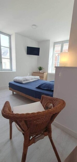 A bedroom with a bed, a TV, a desk, and a chair. - Charming studio Bourgueil center (Bourgueil)