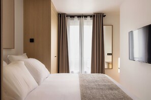 A hotel room with a bed, a TV, and a window with curtains. - Magnificent Studio -2p- Pantheon/ Notre Dame (Paris)