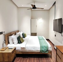 Quarto com cama, cabeceira de madeira, mesa de cabeceira e ventilador de teto.