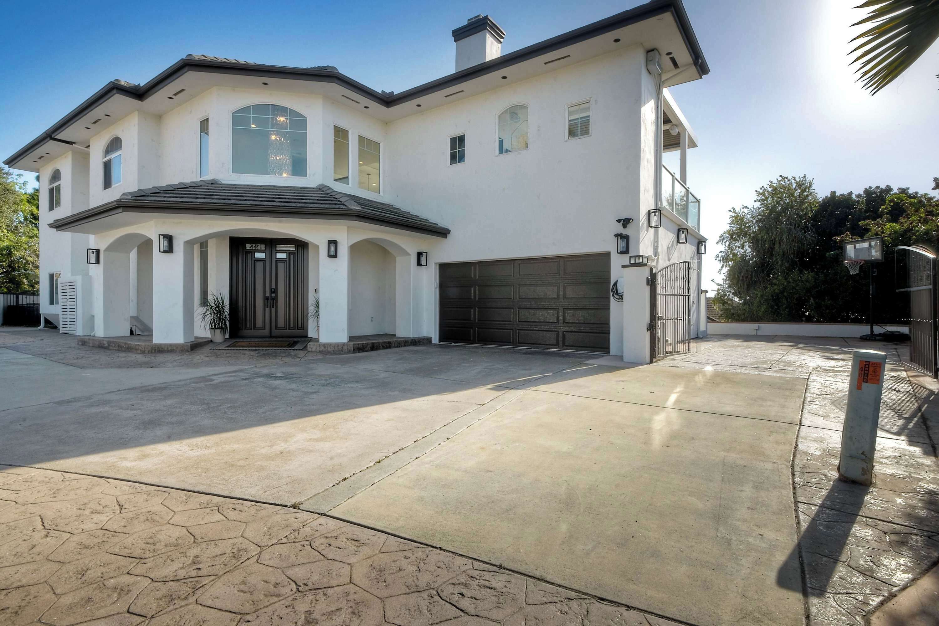A two-story house with a large garage, a covered driveway, and a landscaped front yard.