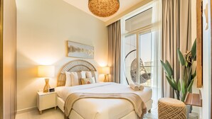 Une chambre moderne avec un grand lit, des lampes de chevet, un élément décoratif mural et une vue sur l’extérieur.