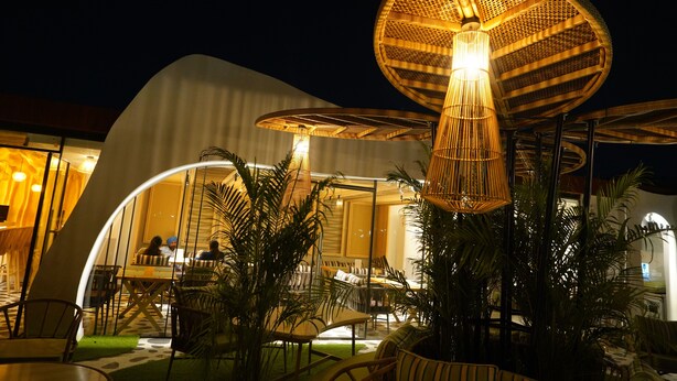 An outdoor dining area with round tables, chairs, and a large umbrella structure. - Clarion Inn Greywall By Choice Hotels (Amritsar)