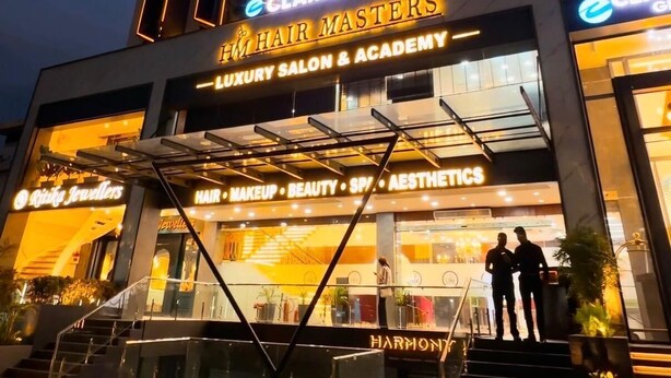 A building with signage for 'eClarion Inn' and 'Hair Masters Luxury Salon & Academy' with a modern architectural design and illuminated signage.