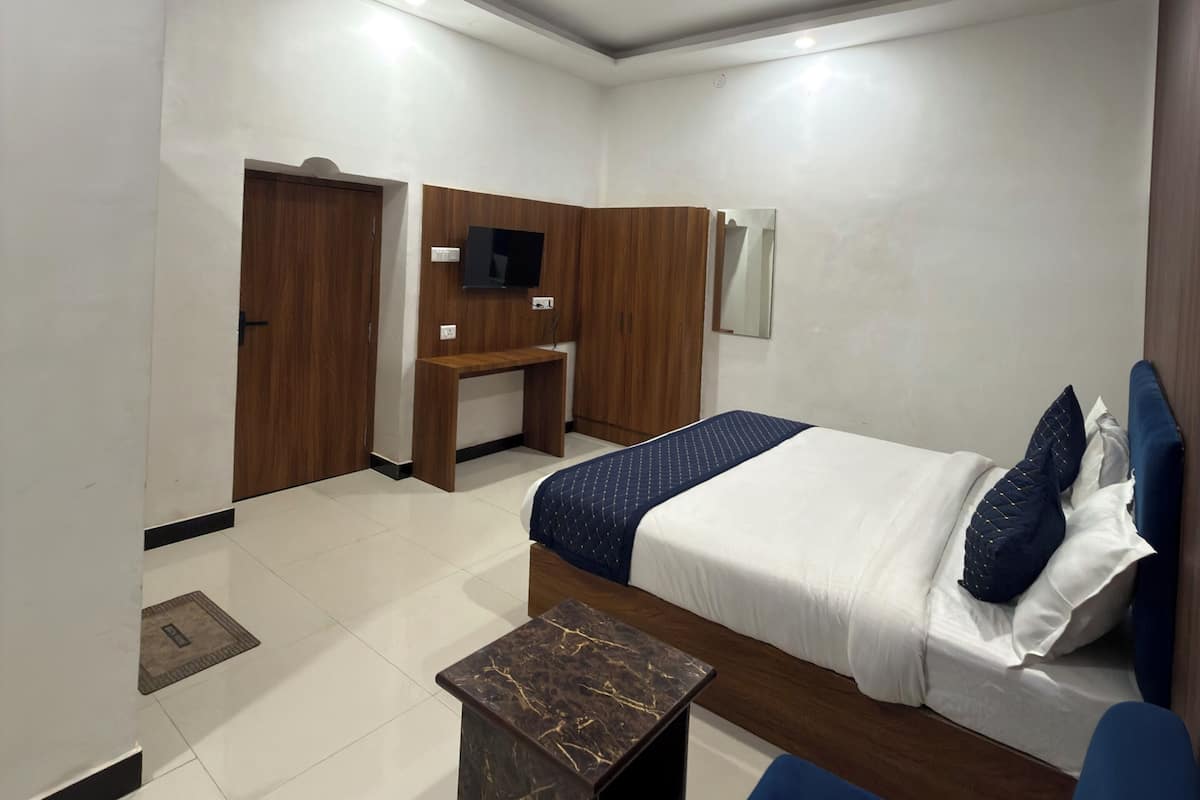 Una habitación de hotel moderna con cama, escritorio, televisor y ventilador de techo.