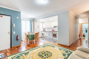 A modern apartment with a dining area, kitchen, and a living room with a large rug. - Lobos Village (Câmara de Lobos)