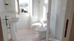 Un bagno con lavandino, WC e doccia.