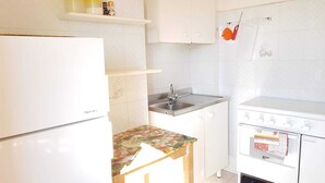 Una cucina compatta con frigorifero, lavello e fornello.