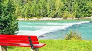 A red bench by a river with a forest backdrop. - Beautiful apartment for 3 people with WIFI, TV and pets allowed (Klausmen)