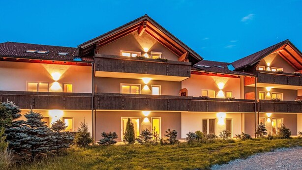 A multi-story building with balconies, large windows, and a gravel path leading to the entrance. - Beautiful apartment for 3 people with WIFI, TV and pets allowed (Klausmen)