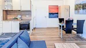 A modern apartment with a kitchen, dining area, and living room. - Beautiful apartment for 3 people with WIFI, TV and pets allowed (Klausmen)