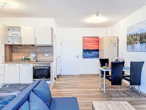 A modern apartment with a kitchen, dining area, and living room. - Nice apartment for 3 guests with WIFI, TV and pets allowed (Klausmen)