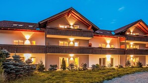 A multi-story building with balconies, large windows, and a gravel path leading to the entrance. - Beautiful apartment for 4 guests with WIFI, TV, balcony, pets allowed and panoramic view (Klausmen)