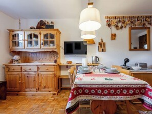 Eine Holz-Küche mit Esstisch, Schränken, einem Fernseher und einem Spiegel.
