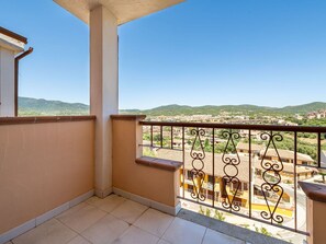 A balcony with a view of a residential area and hills. - Beautiful apartment for 6 guests with WIFI, A/C, TV and terrace (Villasimius)