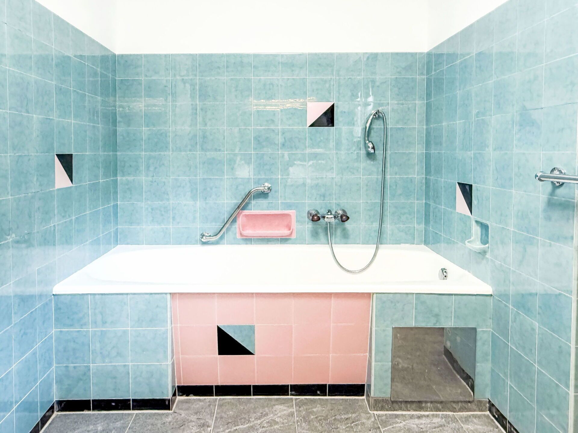 Ein Badezimmer mit einer Badewanne, einer Dusche und einer Handstange.