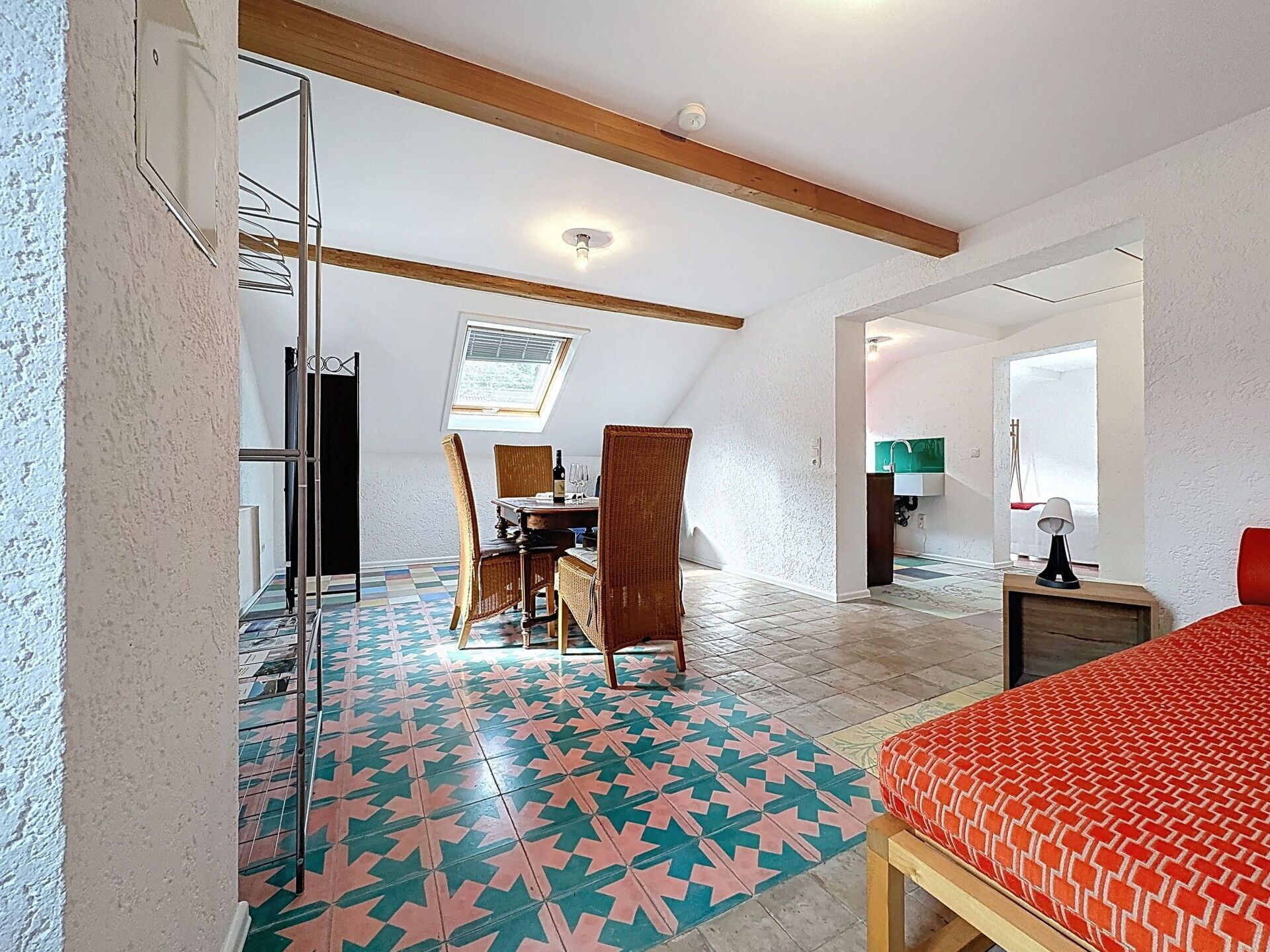 Une pièce comprenant un lit, une table à manger avec des chaises, un coin cuisine et une salle de bain.