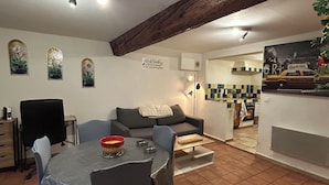 A cozy living room with a dining area, a kitchen, and a tiled floor. - 250m from the Sisteron lake! Fully equipped apartment with office area. (Sisteron)