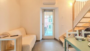 Une petite pièce agréable, avec un lit, une table et un escalier.