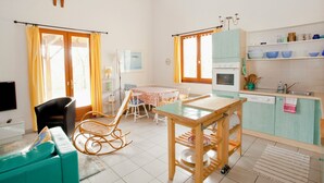 A bright kitchen with a dining table, chairs, and a wooden rocking chair. - Bright country house with open kitchen (Saint-Jean-de-Laur)