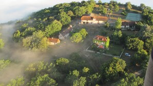 An aerial view of a rural village with several houses, a tennis court, and a church. - Bright country house with open kitchen (Saint-Jean-de-Laur)