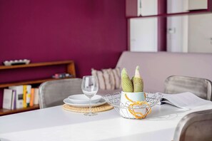 A dining table with a white tablecloth, a wine glass, a basket with a cactus, and a book. - Casa Marion Charming Home Near the Center (Bologna)