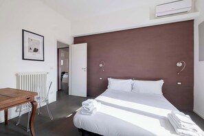 A hotel room with a bed, a desk, a chair, and a radiator. - Casa Marion Charming Home Near the Center (Bologna)