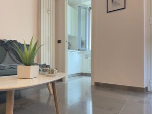 A modern living room with a round table, a potted plant, and a sofa. - Casa Luca Near University Metro (Milan)