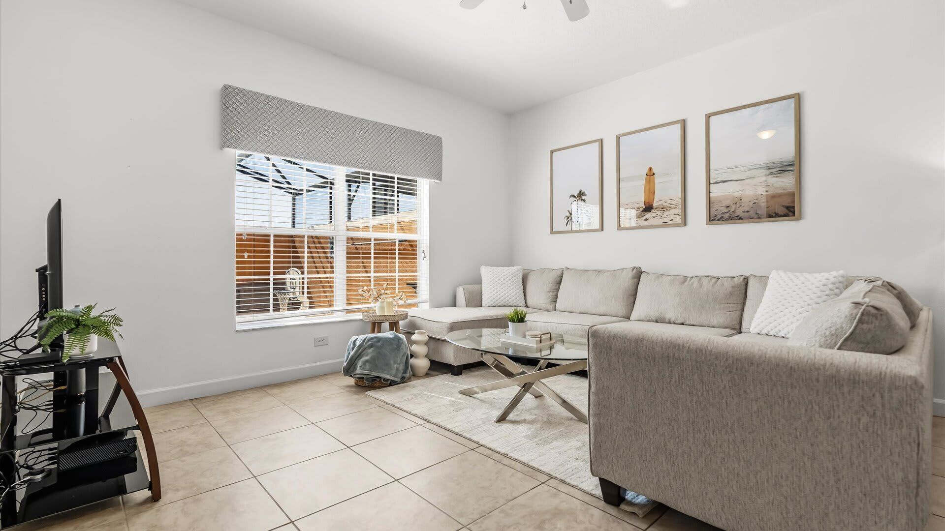A modern living room with a sofa, coffee table, and a TV on a stand.