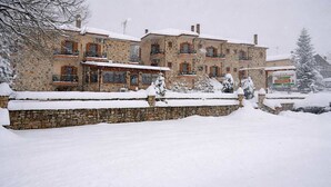 A stone building with multiple balconies, surrounded by snow.
