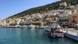 A coastal town with a marina, buildings, and a hill in the background. - Casa Azul Villa - Seafront Getaway in Kalymnos (Kalymnos)