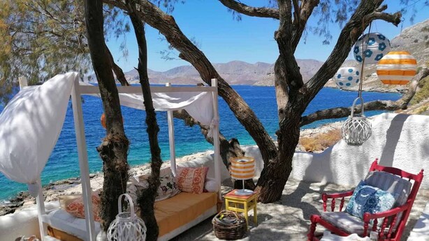 A beachside seating area with a canopy, a sofa, a chair, and a small table with a lamp. - Casa Azul Villa - Seafront Getaway in Kalymnos (Kalymnos)
