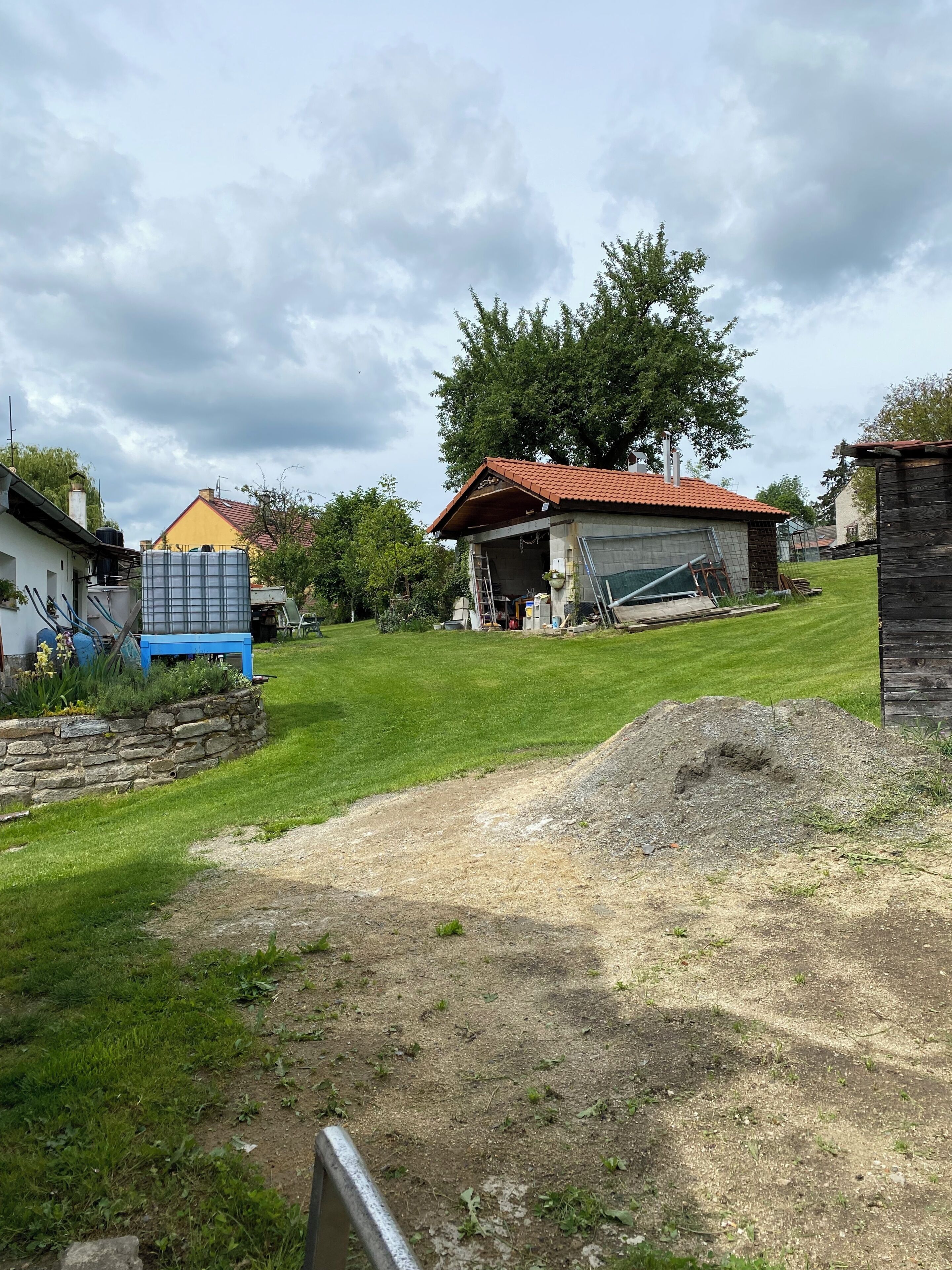 Un quartier résidentiel comprenant une maison, un garage et un grand arbre.
