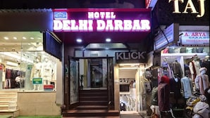 The entrance to Hotel Delhi Darbar with a neon sign, a visible staircase, and a clothing store named 'KLICK SELECTION' to the right. - Hotel Delhi Darbar-Near Karolbagh Metro (New Delhi)