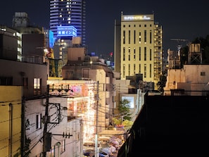 A cityscape at night with illuminated buildings, including a hotel named "Superhotel Premier" and another building with a blue sign.