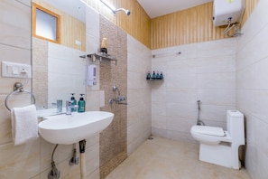 Un baño con lavamanos, espejo, toallero, ducha e inodoro.