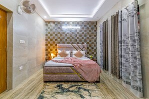 Un dormitorio con cama, ventilador de techo, baldosas estampadas en las paredes y cortinas.