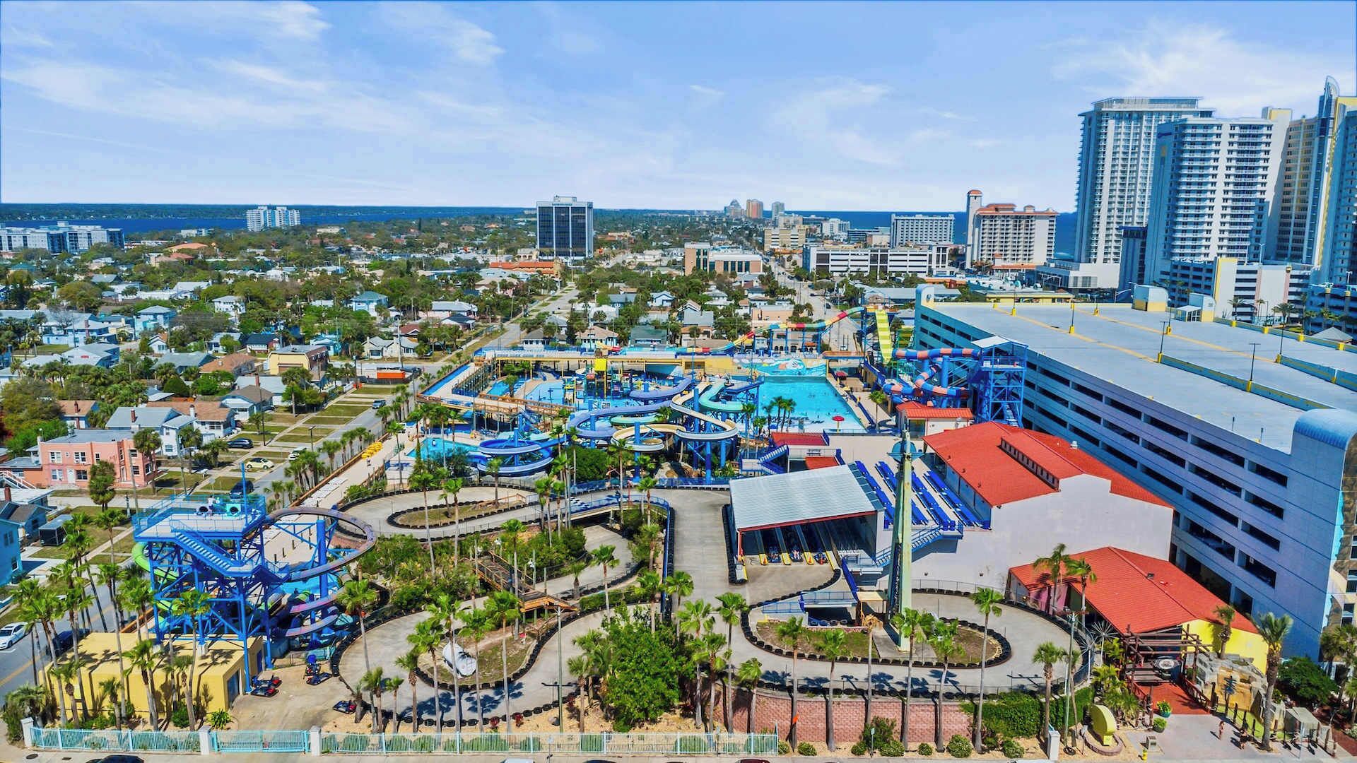 A resort with multiple water parks, a large pool, and a parking area.