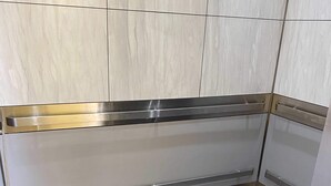 Ein moderner Aufzug mit metallischen Wänden und einem grauen Boden.