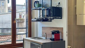 Une cuisine compacte équipée d’un évier encastré, d’un four à micro-ondes et d’un petit réfrigérateur.