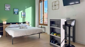 Une chambre d’hôtel moderne équipée d’un lit, d’un bureau, d’une bibliothèque et d’un téléviseur.