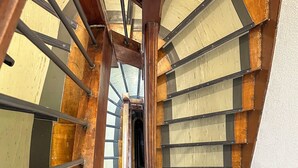 Un escalier en bois avec des rampes en métal et une balustrade en verre.